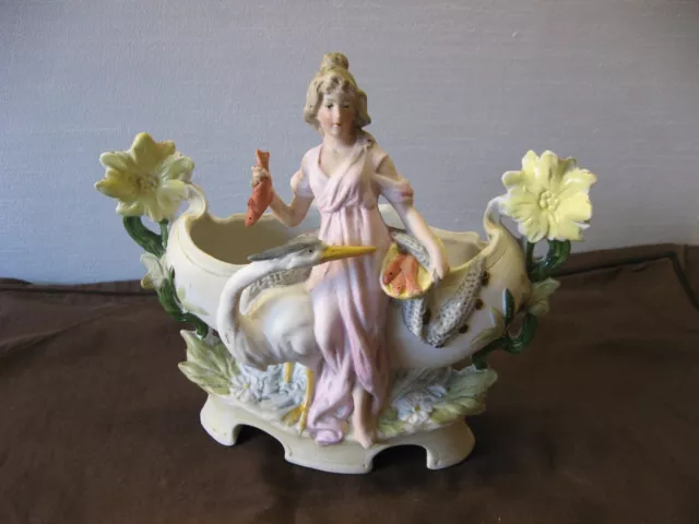 Magnifique sujet en porcelaine biscuit, femme poissonnière et héron vers 1900-20