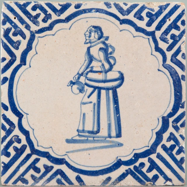 Nice Dutch Delft Blue tile, figure with basket & jug, first half 17th. century.