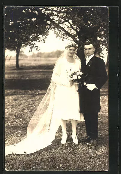 Junges Brautpaar mit Schleier und Blumen im Garten stehend, Ansichtskarte