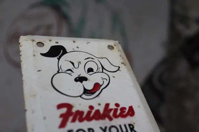 1960s FRISKIES WINKING DOG FOOD DOOR PULL HANDLE STAMPED PAINTED METAL SIGN 10"