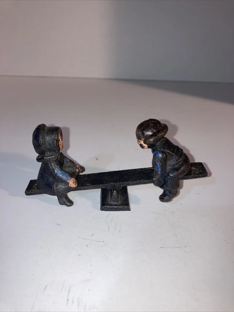 Vintage Cast Iron Amish Boy And Girl in Blue Shirts Playing 0n see-saw Vintage Cast Iron Amish Boy And Girl in Blue Shirts Playing 0n see-saw
