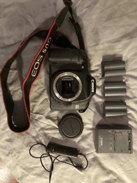 Canon EOS 50D camera body with 3 batteries, charger, shutter remote, and bag