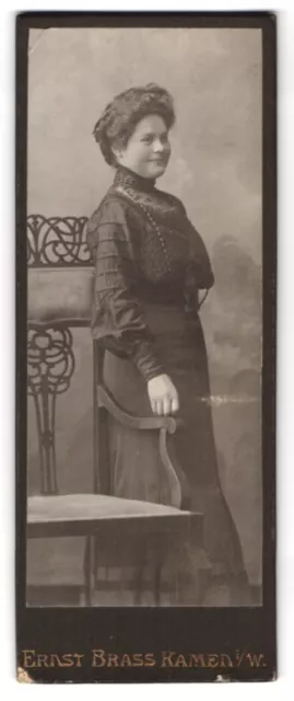 Fotografie Ernst Brass, Kamen i. W., Frau im schwarzen Abendkleid lehnt an eine