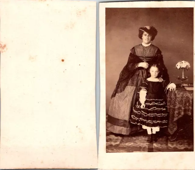 Une femme en robe à crinoline et chapeau à plumes et sa fille posent Vintage CDV