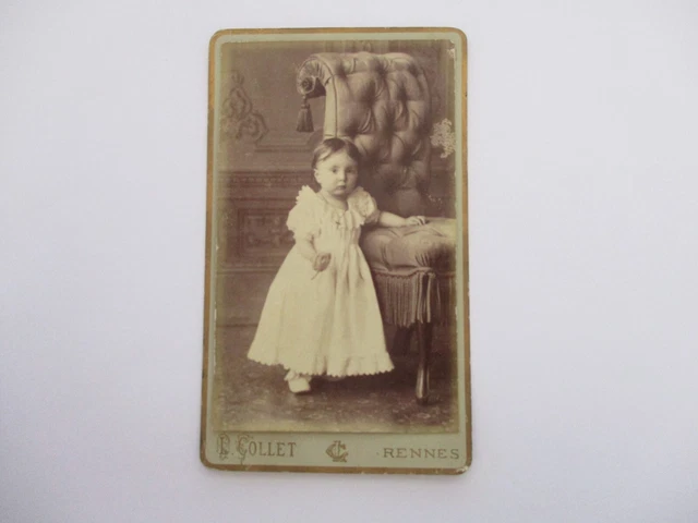 Petite Fille Est Assise Sur Une Chaise Posant Sur Caméra image libre de