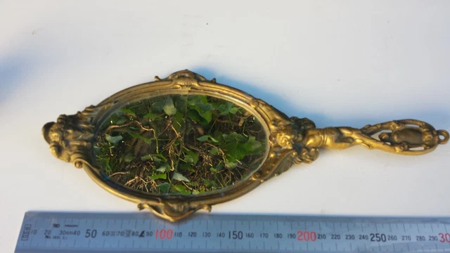 Ancien miroir de coiffeuse, face à main en bronze à décor angelot et mascaron.