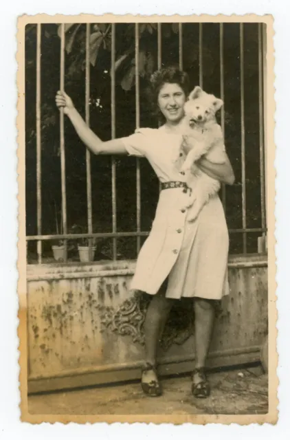 PHOTO snapshot - Femme en robe portail grille et son chien dans les bras dog