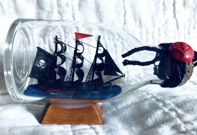 Vintage Black Ship w/ Skulls In A Bottle On Stands 4.5" Long x 2.5" Tall Boat