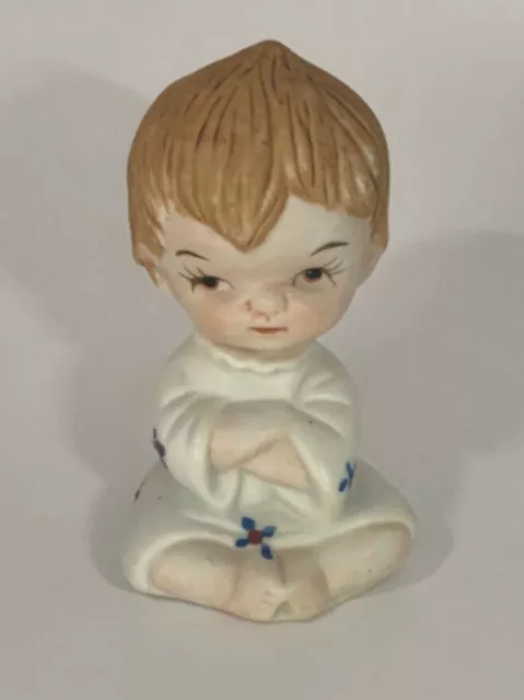 Petit garçon bébé en chemise de nuit avec figurine bleue et rouge en colère