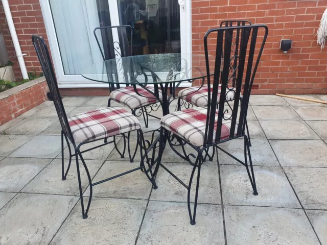 Glass and Cast Iron Table with fabric tartan style chairs. Delivery Possible.