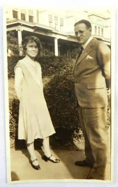 Man with Suit and Woman in Patterned Dress on Sidewalk Portrait - Photograph