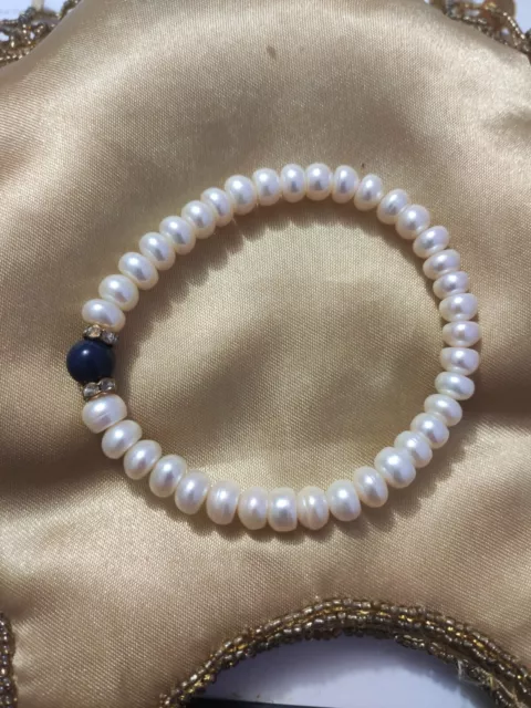 très joli bracelet en perles de culture très bon état avec élastique