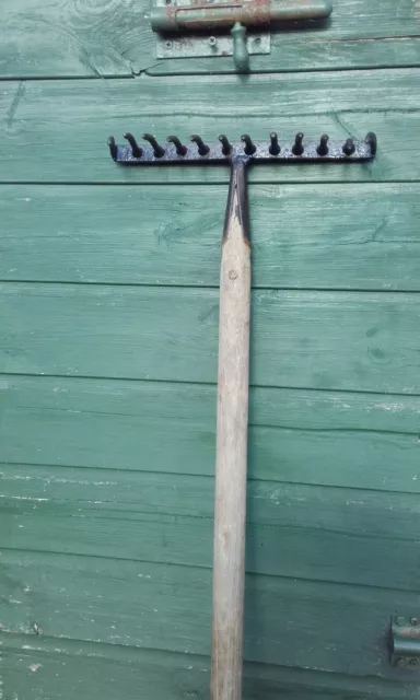 Vintage garden rake with riveted tines