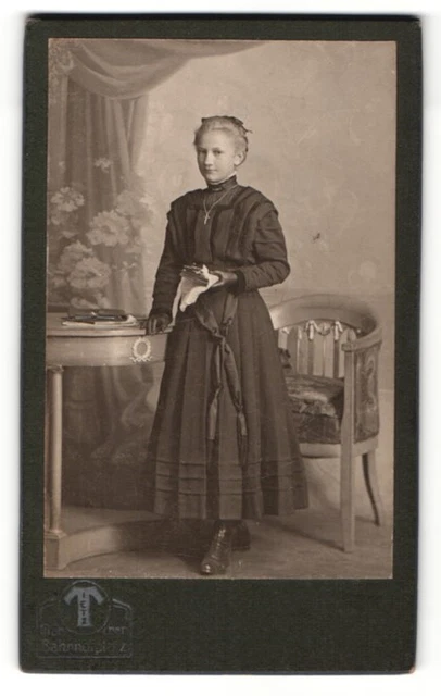 Fotografie Hermann Tietz, München, junge Frau mit schwarzen Handschuhen am Tisc
