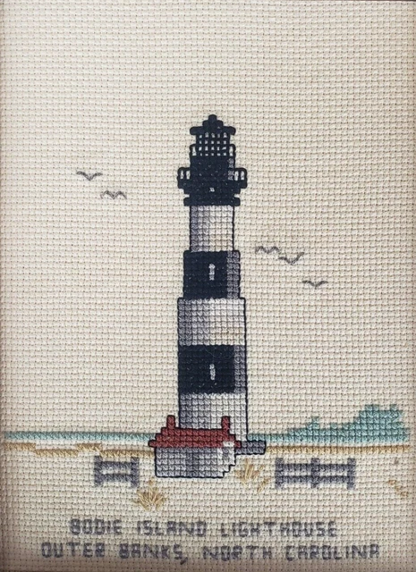 Faro de isla con punto de cruz acabado bancos exteriores playa de Carolina del Norte