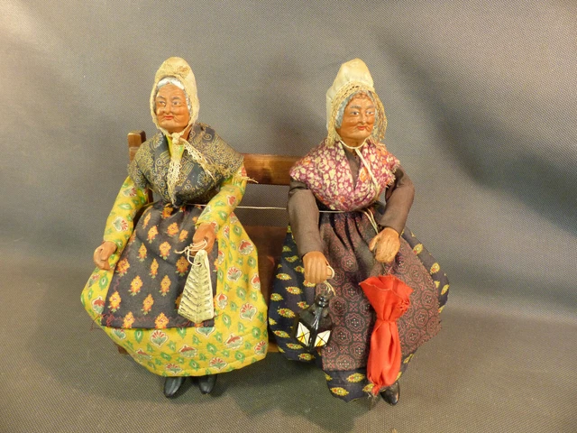 Anciens sujets en terre cuite santon paysanne bretonnes sur un banc camapagne