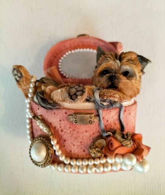objet de décoration avec 3 paquets cadeau doré et un pomme de pin sur