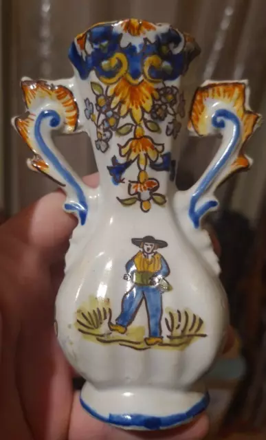 Un petit vase en porcelaine polychrome décor de paysan signé Mont-Dore