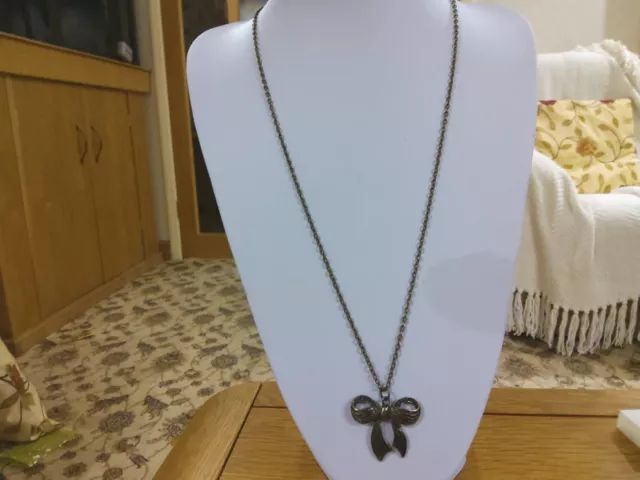 Brand new long antique look chain necklace with a bow shaped pendant
