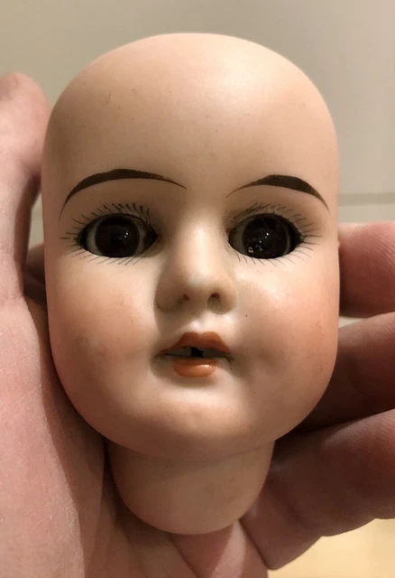 Grande tête de poupée sur présentoir antique