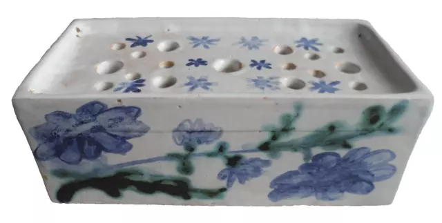 Blue and white ceramic flower brick with a floral motif  the base marked 'D C' .