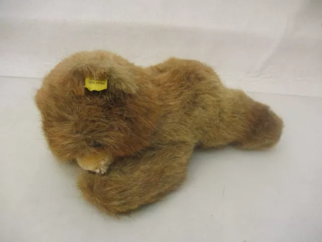 x-79906	Steiff Teddy Bär liegend weichgestopft mit Knopf und Fahne L: ca.21cm