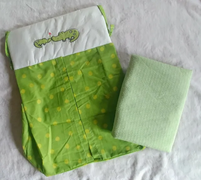 Hanging diaper holder with coordinating swaddle blanket in green nursery decor