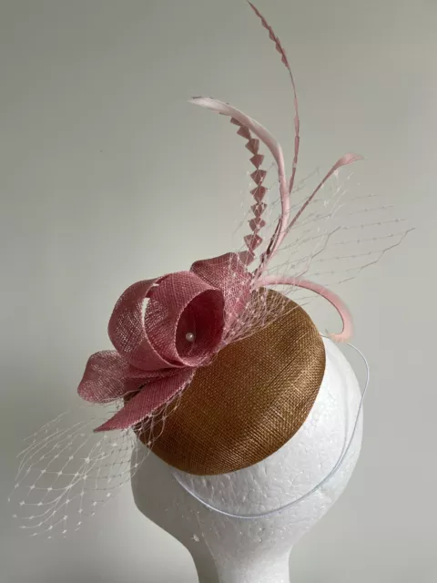 Gold fascinator with round base and pink loops, netting and feathers