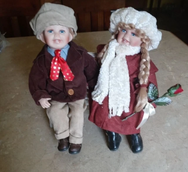 Vintage Boy and Girl porcelain dolls sitting on a wooden bench