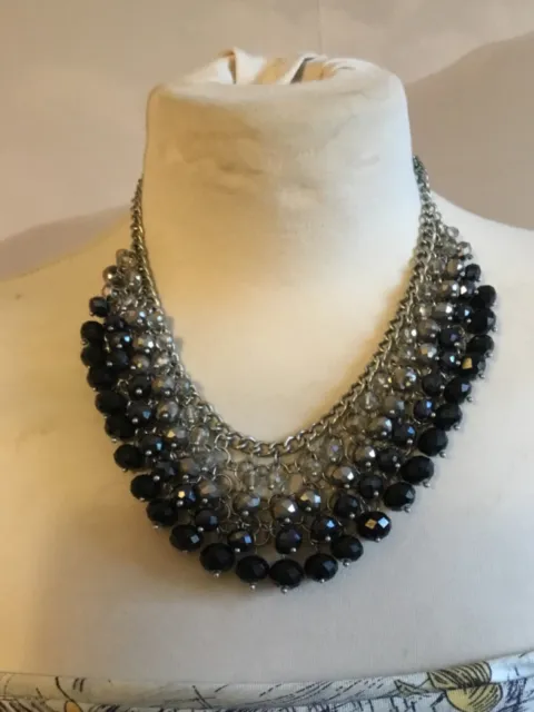 Joli collier plastron 4 rangs de perles RN noir gris argenté en très bon état.