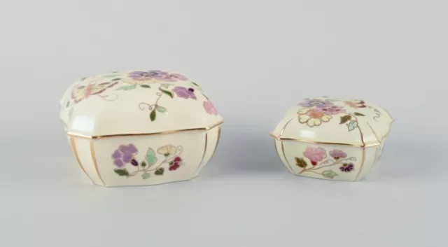 Zsolnay, Hungary, two lidded jars in porcelain hand-painted with flower motifs. 2