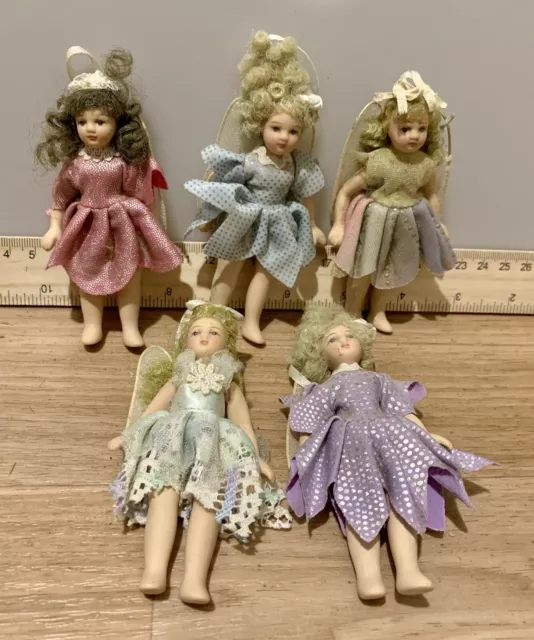 5 Small Dolls made of porcelain some in fairy dresses mixed lot