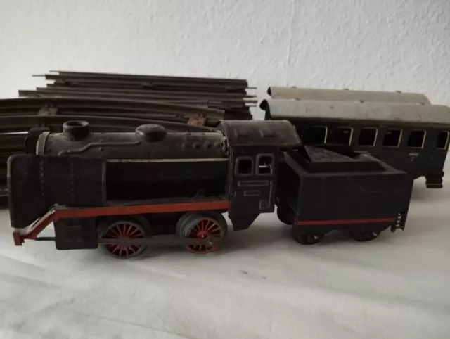 Konvolut Blecheisenbahn Lokomotive mit 2 Wagen und Schienen.