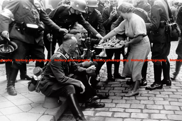 F019029 A woman in Gdansk handing food to invading German soldiers. c1939. WW2