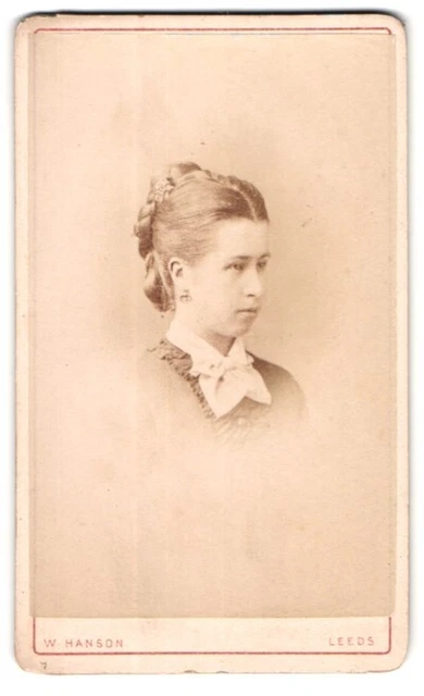 Fotografie W. Hanson, Leeds, Junge Frau mit Duttfrisur und ernstem Blick