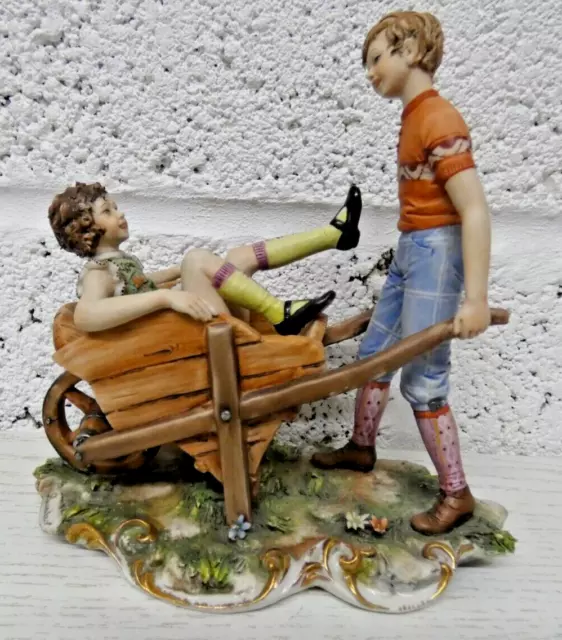 Capodimonte  Figurine Boy & Girl in Wheelbarrow by Sandro Maggioni  (Hea]