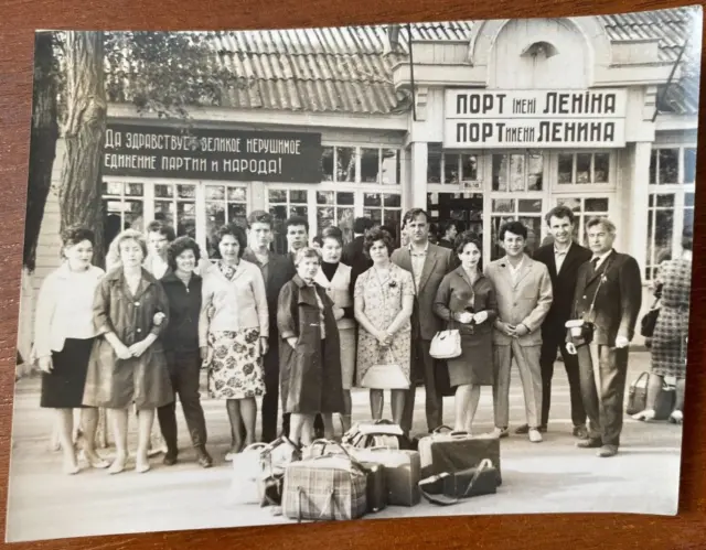 Affectionate men and women in port, man with camera Vintage photo