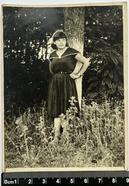 Old photo beautiful young girl in a dress near a tree, Cute affectionate woman