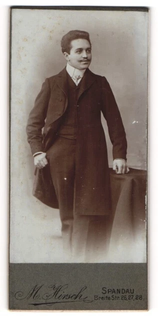 Fotografie M. Hirsch, Berlin-Spandau, Portrait elegant gekleideter Herr an Tisc