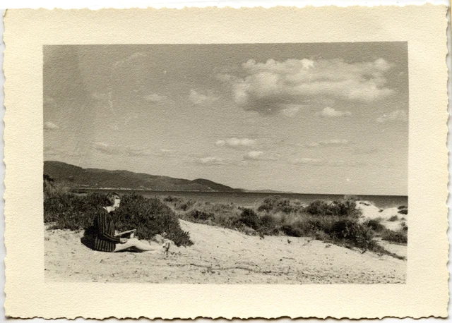 Woman sitting on the beach - old year photo. 1949