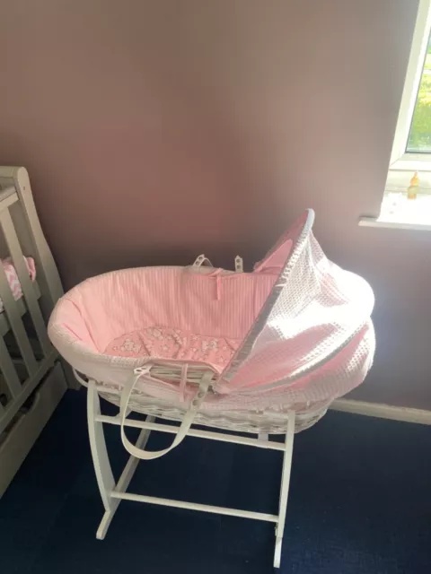 pink and white moses basket with stand