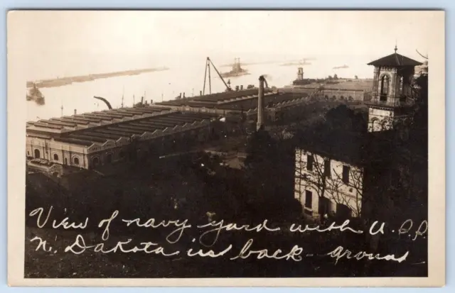 1910-20's RPPC NAVY YARD WITH USS NORTH DAKOTA IN BACKGROUND BATTLESHIP POSTCARD