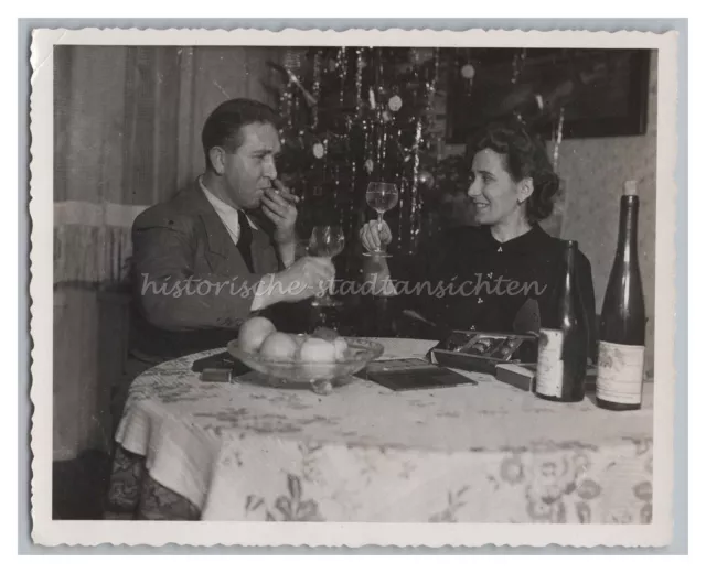 Mann mit Zigarre und Frau stoßen an Weihnachten mit Wein an - Altes Foto 1930er