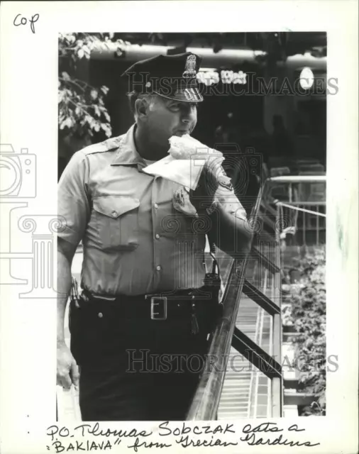 1982 Press Photo Police Officer Thomas Sobczak, eats a "Baklava," Milwaukee.