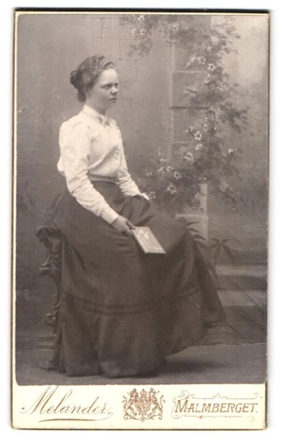 Fotografie Melander, Malmberget, Portrait junge Frau im Kleid mit Buch in der H