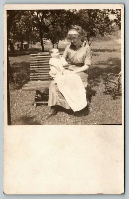 RPPC Young Lady on Bench Holds Realistic-Looking Baby Boy Doll on Her Lap c1910