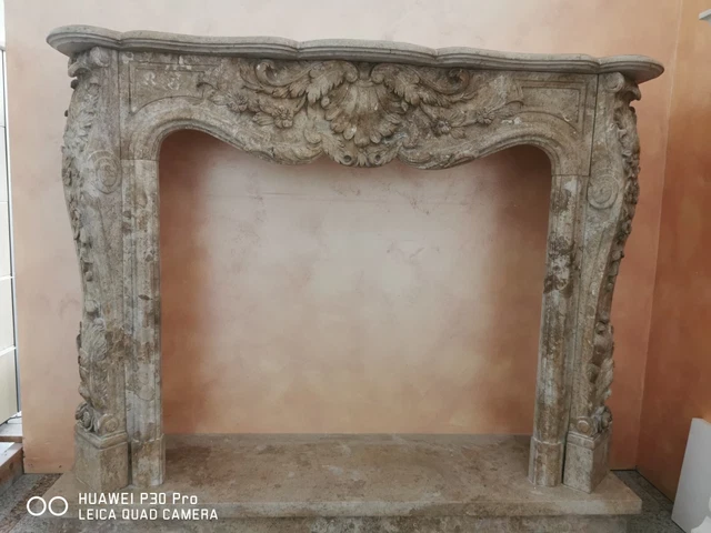 Camino in travertino noce con lavorazione a basso rilievo 