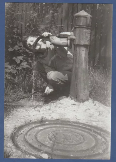 Beautiful boy drinks water from a street tap. Soviet Vintage Photo USSR