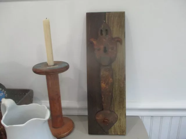 Large old barn door handle on piece of wood. Design is great.