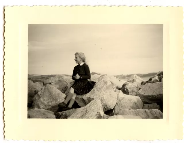 Jeune fille assise sur rochers - photo ancienne an. 1950